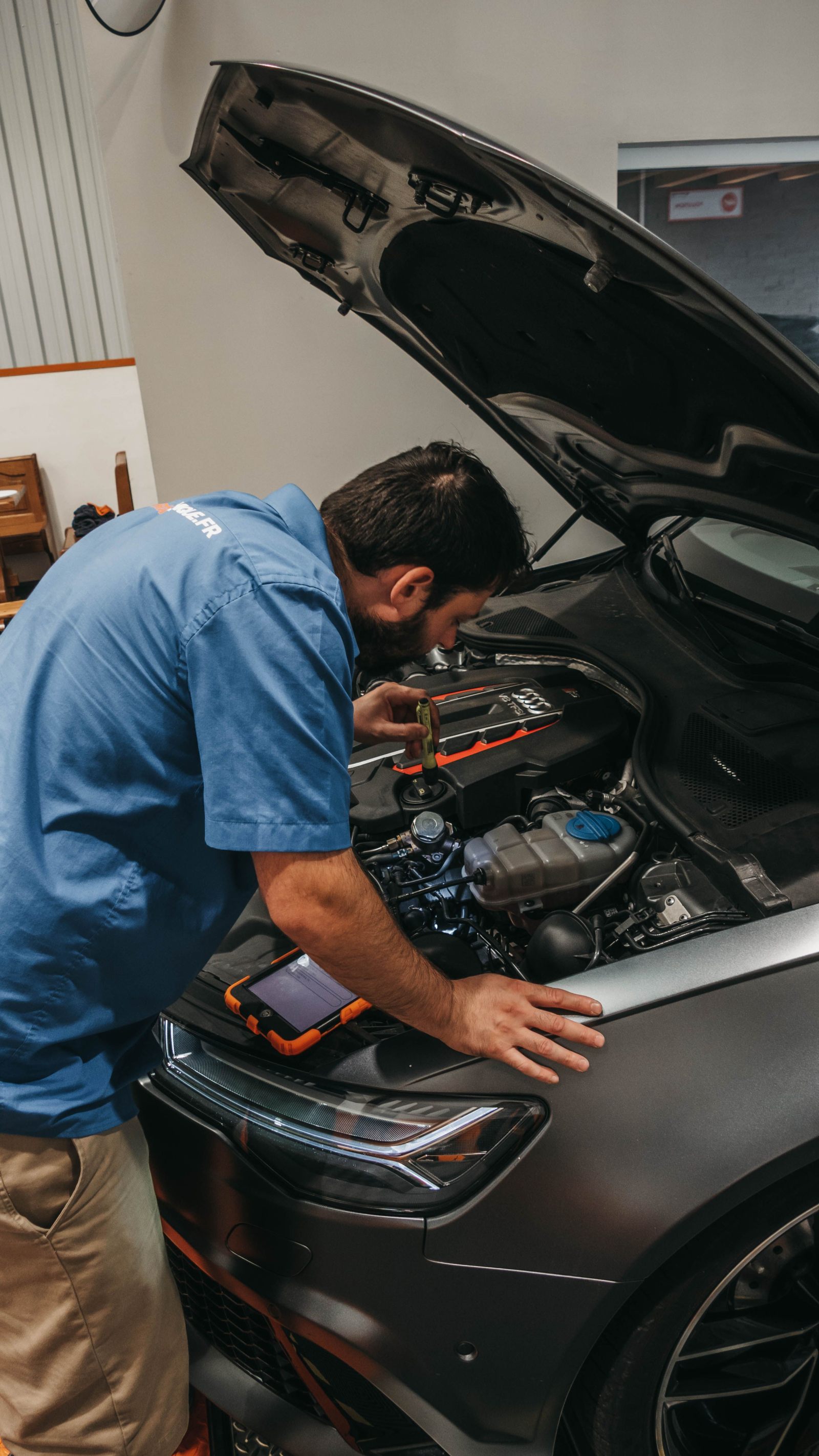 Technicien effectuant un diagnostic électronique sous le capot